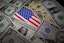 In this photo illustration, some U.S. dollar bills and an American flag are displayed on a table. (Photo by Sheldon Cooper / SOPA Images/Sipa USA) 