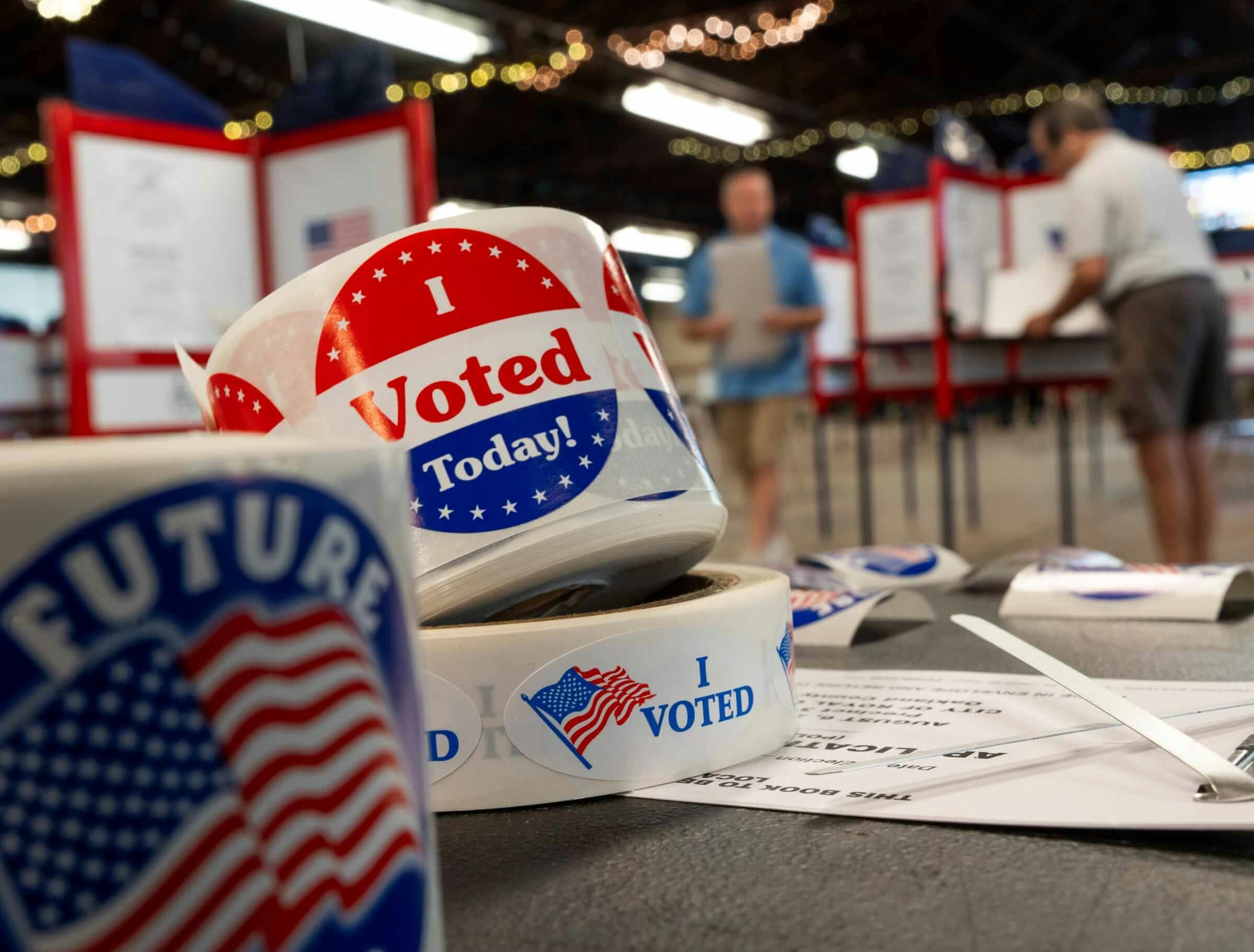 People prepare to cast their ballots while voting in the Michigan Primary elections at the Royal Oak Farmers Market in Royal Oak on Tuesday, Aug. 6, 2024.