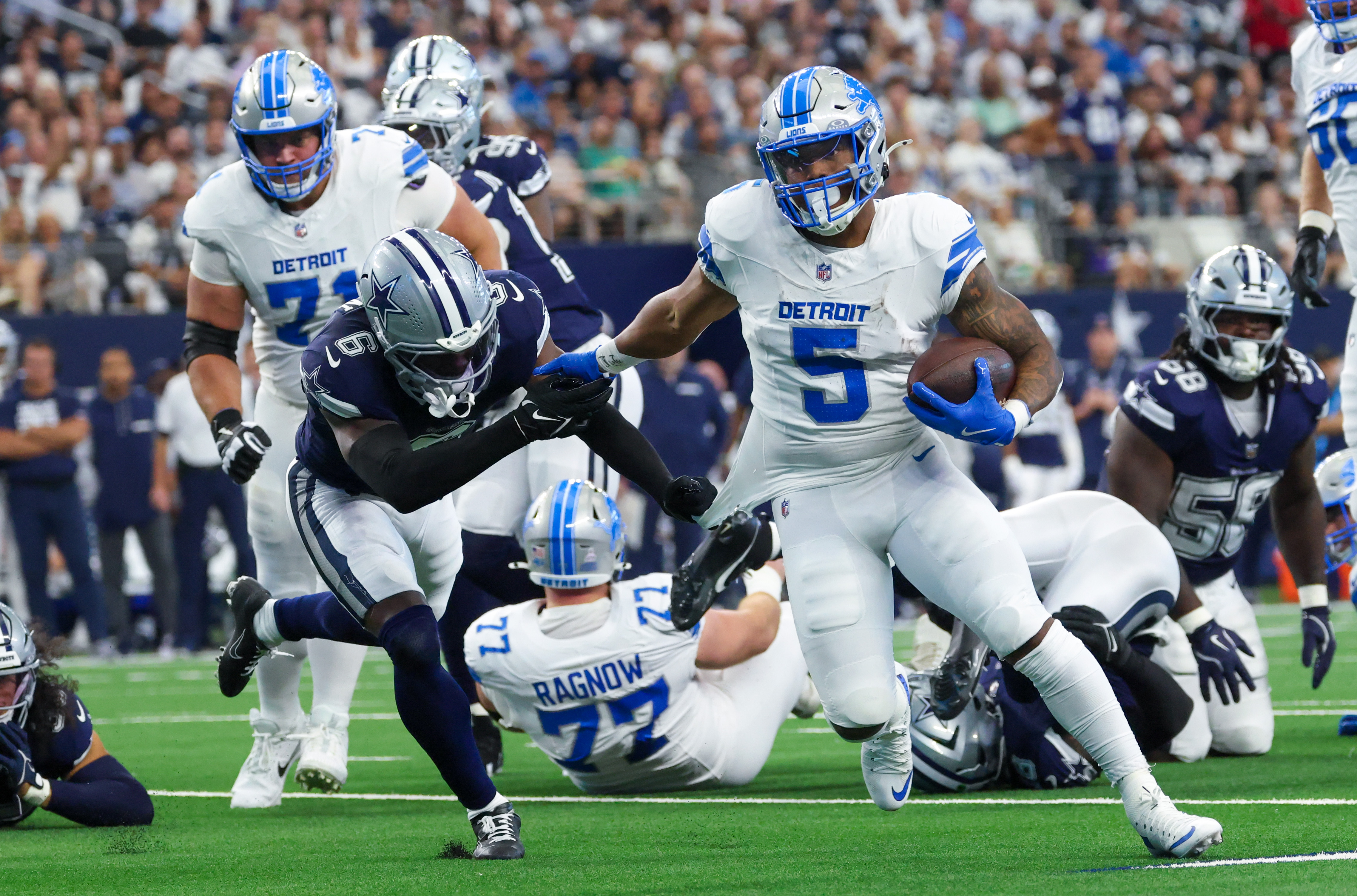 Detroit Lions running back David Montgomery (5) runs for a touchdown as Dallas Cowboys safety Donovan Wilson (6) defends during the first quarter at AT&T Stadium. Mandatory Credit: Kevin Jairaj-Imagn Images