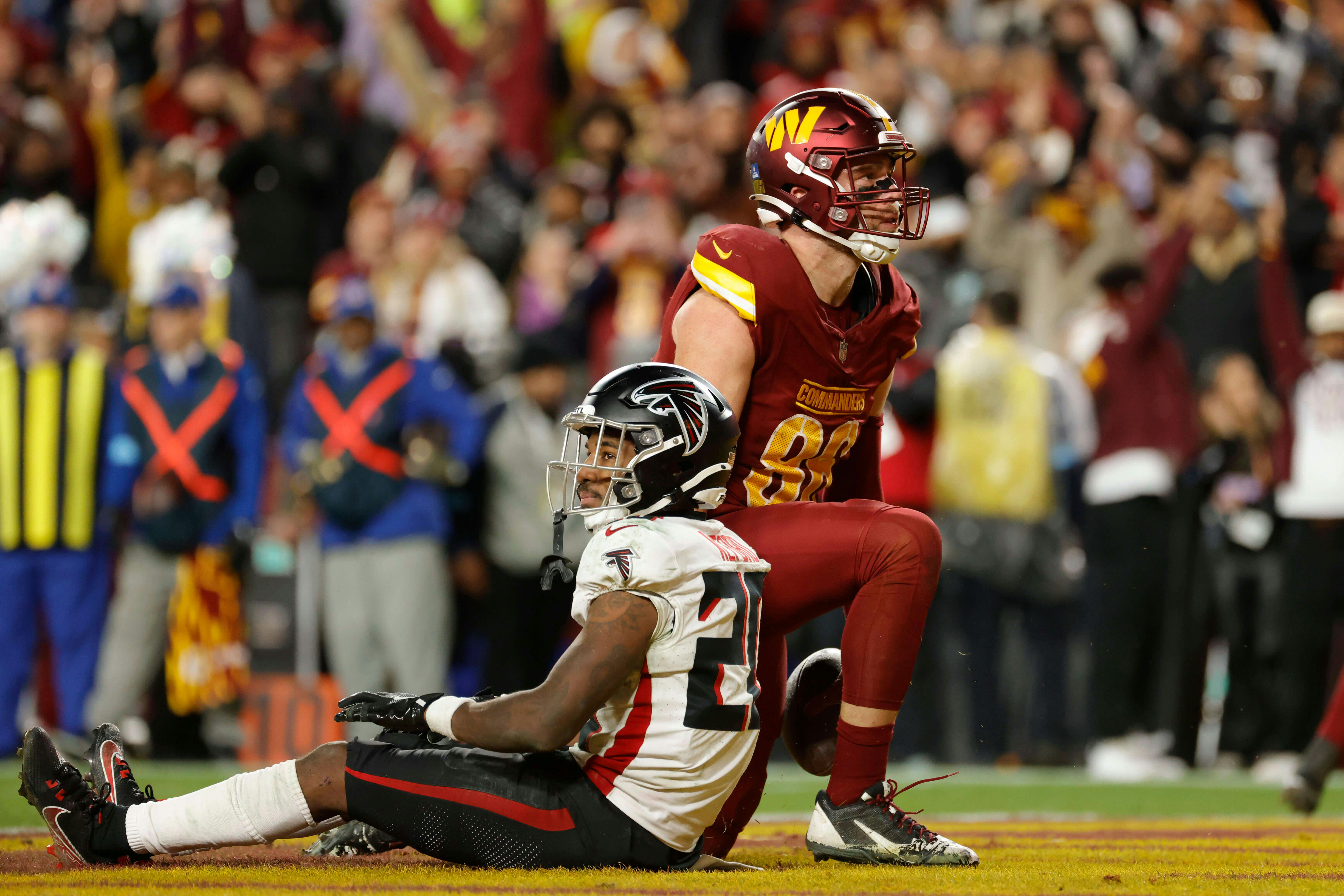 Washington Commanders tight end Zach Ertz (86) celebrates after scoring the game winning touchdown in front of Atlanta Falcons cornerback Dee Alford (20) during overtime at Northwest Stadium. Mandatory Credit: Amber Searls-Imagn Images