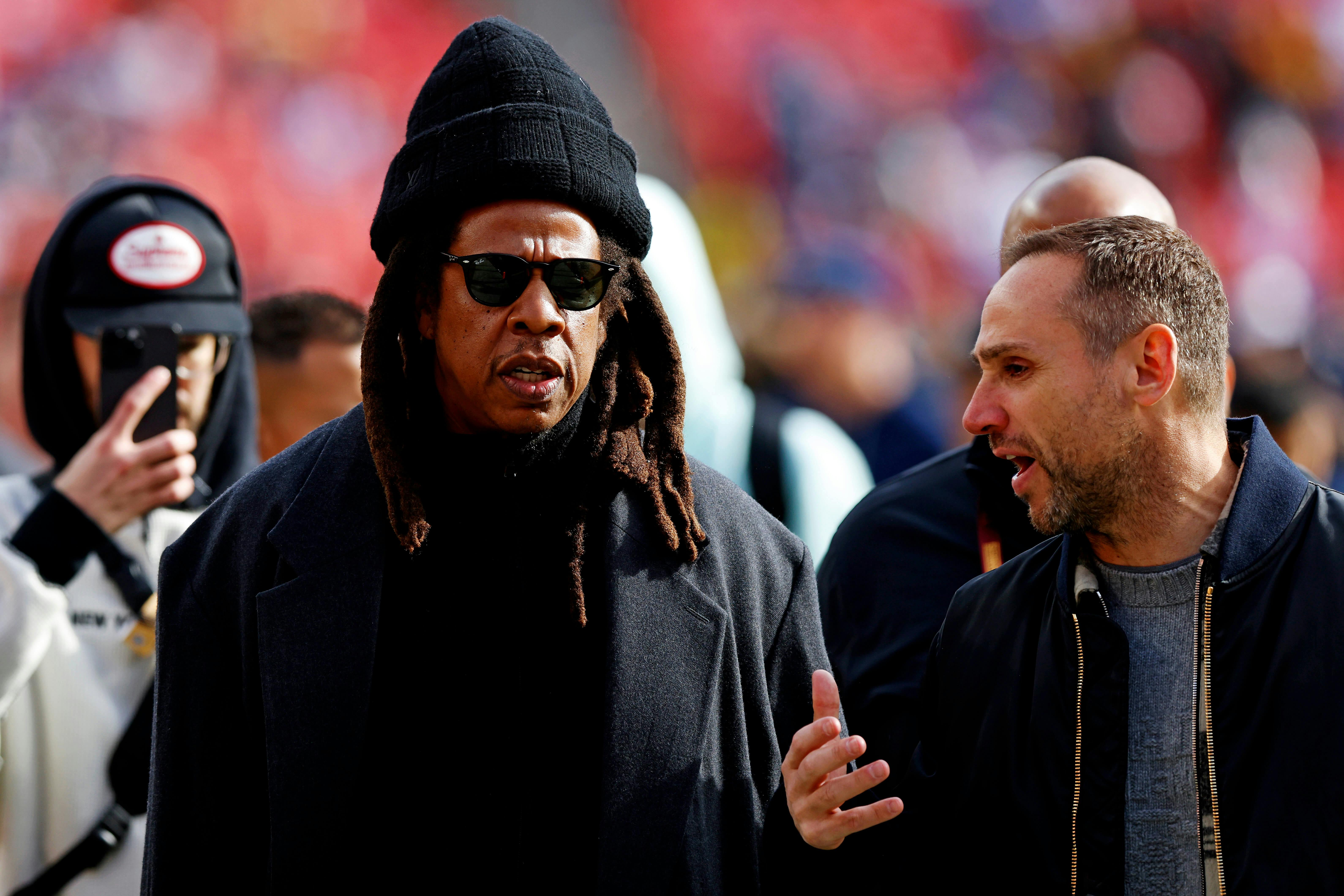 Recording artist Jay-Z walks on the field before the game between the Washington Commanders and the Dallas Cowboys at Northwest Stadium. Peter Casey-Imagn Images