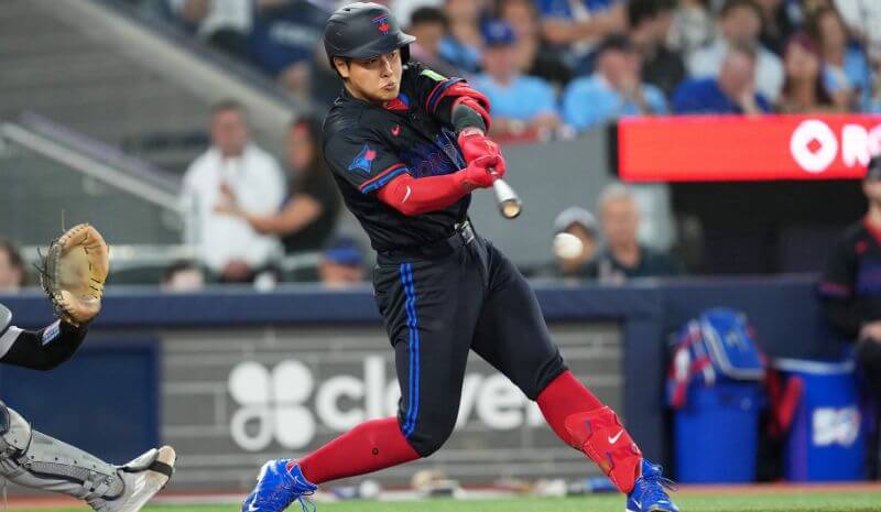 Toronto Blue Jays third baseman Kazuma Okamoto (7) gets on first base.