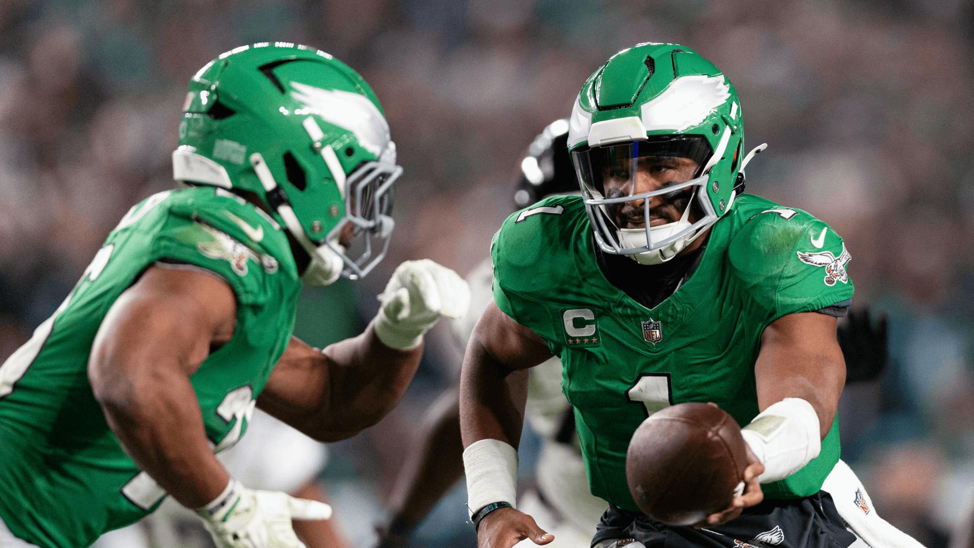 Philadelphia Eagles quarterback Jalen Hurts (1) hands off to running back Saquon Barkley (26) in a game against the Jacksonville Jaguars.