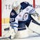 Winnipeg Jets goaltender Connor Hellebuyck (37) reaches to stop a puck during the second period of a game against the Calgary Flames at Scotiabank Saddledome.