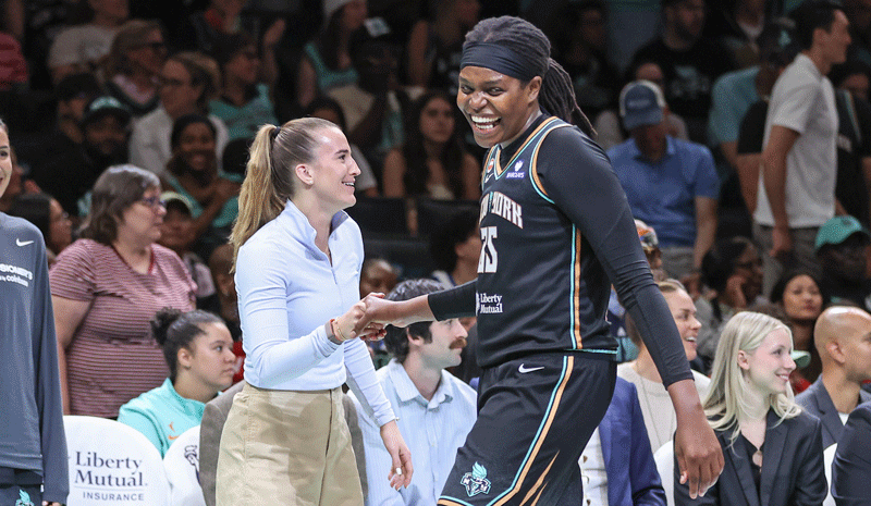 Sabrina Ionescu (not in uniform) celebrates with center Jonquel Jones
