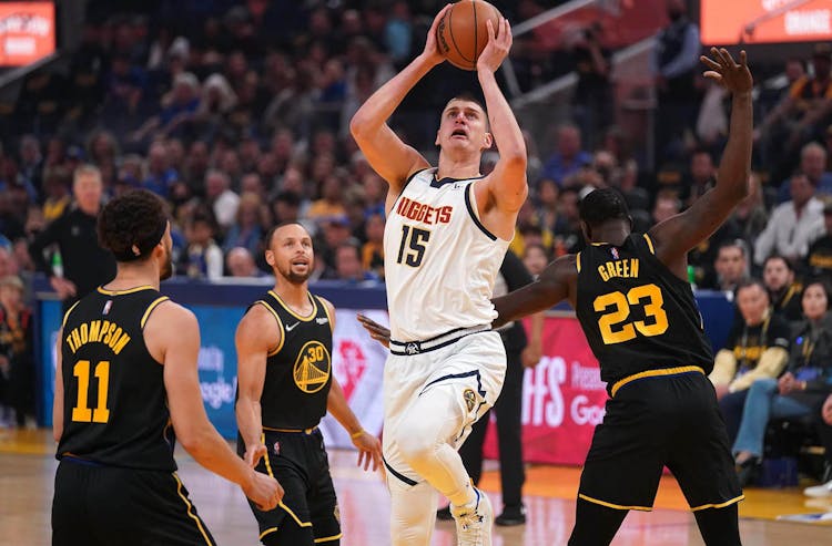 Denver Nuggets center Nikola Jokic (15) shoots the ball in front of Golden State Warriors forward Draymond Green (23) in the first quarter during game five of the first round for the 2022 NBA playoffs at Chase Center.