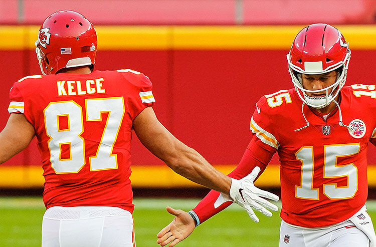 Kansas City Chiefs stars Travis Kelce and Patrick Mahomes share a low-five on the field during NFL action.