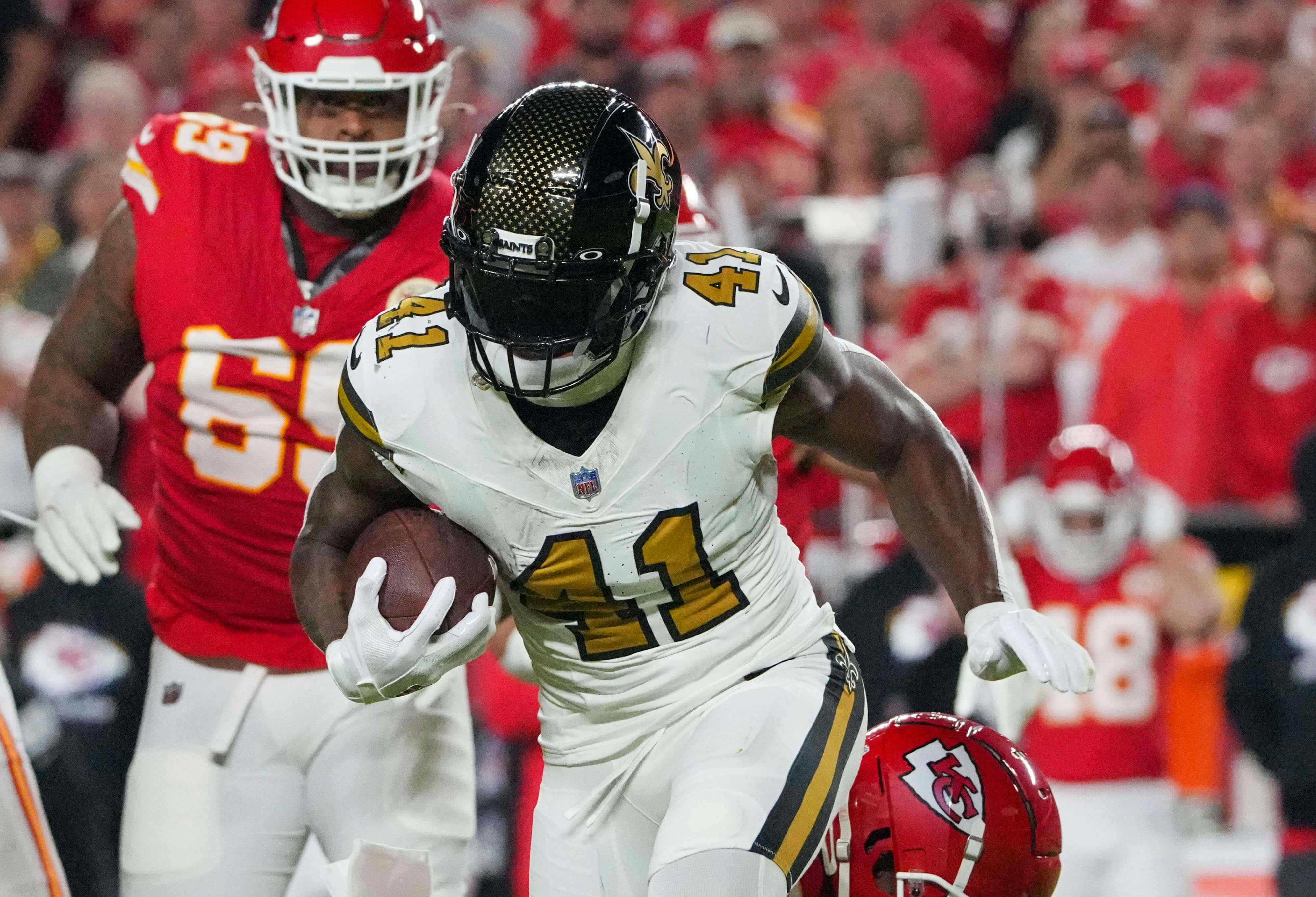 Imagn Images. Pictured: Alvin Kamara taking off with the ball. 