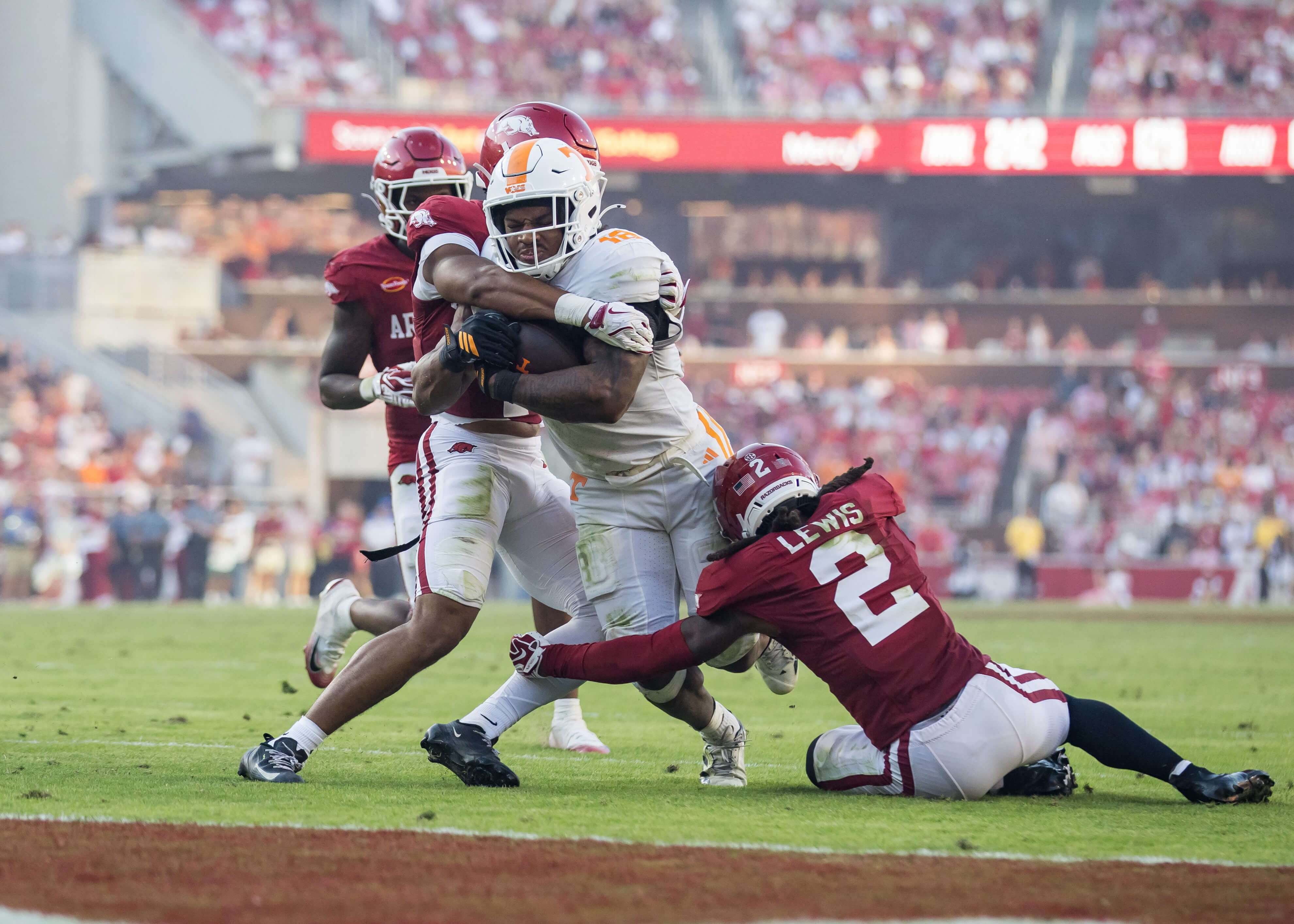 Alabama vs Tennessee AI predictions, Arkansas Razorbacks defensive back Shelton Lewis (2) and defensive back Christian Harrison (1) tackle Tennessee Volunteers running back DeSean Bishop (18) short of the goal line.