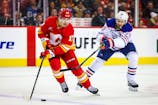 Calgary Flames center Yegor Sharangovich (17) and Edmonton Oilers center Leon Draisaitl (29) battles for the puck during the third period at Scotiabank Saddledome. Mandatory Credit: Sergei Belski-Imagn Images