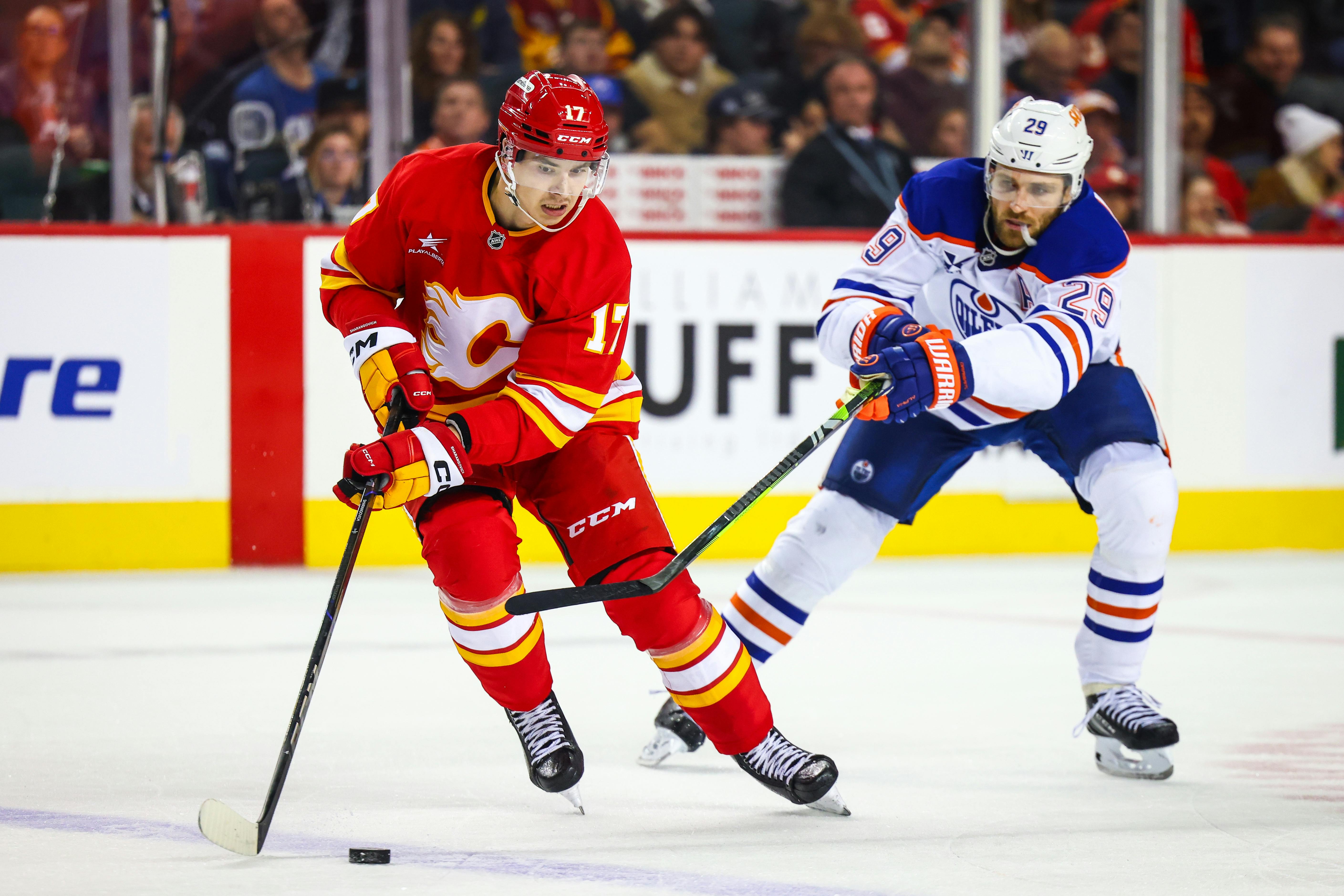 Calgary Flames center Yegor Sharangovich (17) and Edmonton Oilers center Leon Draisaitl (29) battles for the puck during the third period at Scotiabank Saddledome. Mandatory Credit: Sergei Belski-Imagn Images