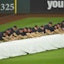 The Progressive Field grounds crew unrolls the tarp during a rain delay.