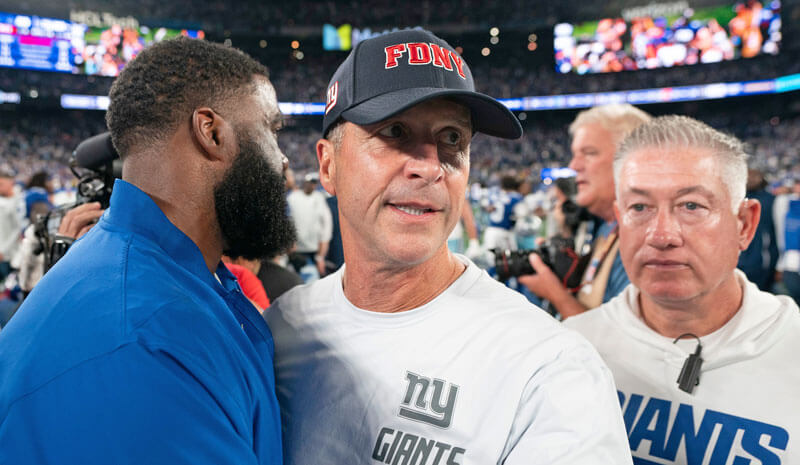 New York Giants head coach John Harbaugh talks with coaches following a 28-20 victory over Dallas.