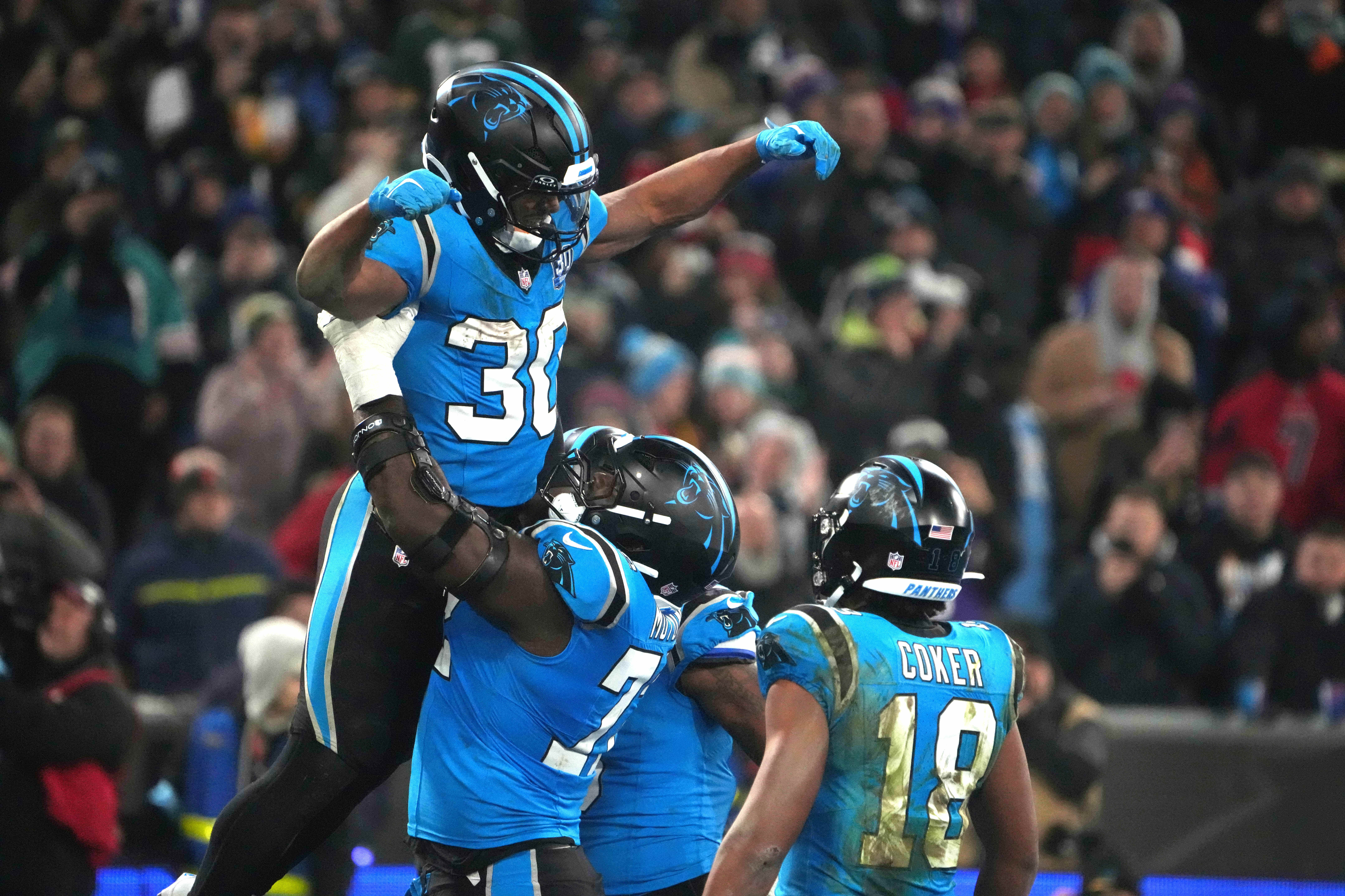 Carolina Panthers running back Chuba Hubbard (30) celebrates with offensive tackle Taylor Moton (72) and wide receiver Jalen Coker (18) after scoring on a 1-yard touchdown run against the New York Giants in the second half during the 2024 NFL Munich Game.