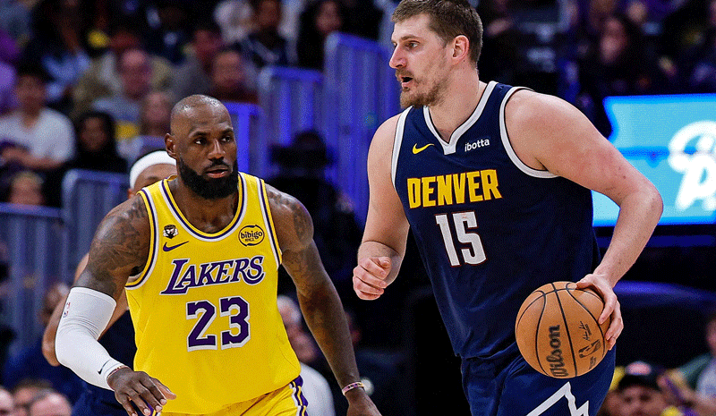 Nikola Jokic (15) controls the ball as Los Angeles Lakers forward LeBron James (23) guards in the fourth quarter at Ball Arena.
