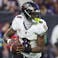 Baltimore Ravens quarterback Lamar Jackson looks downfield for a receiver.