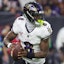 Baltimore Ravens quarterback Lamar Jackson looks downfield for a receiver.