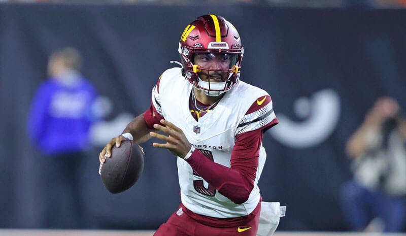 Washington Commanders rookie quarterback Jayden Daniels races down the field in NFL action. 