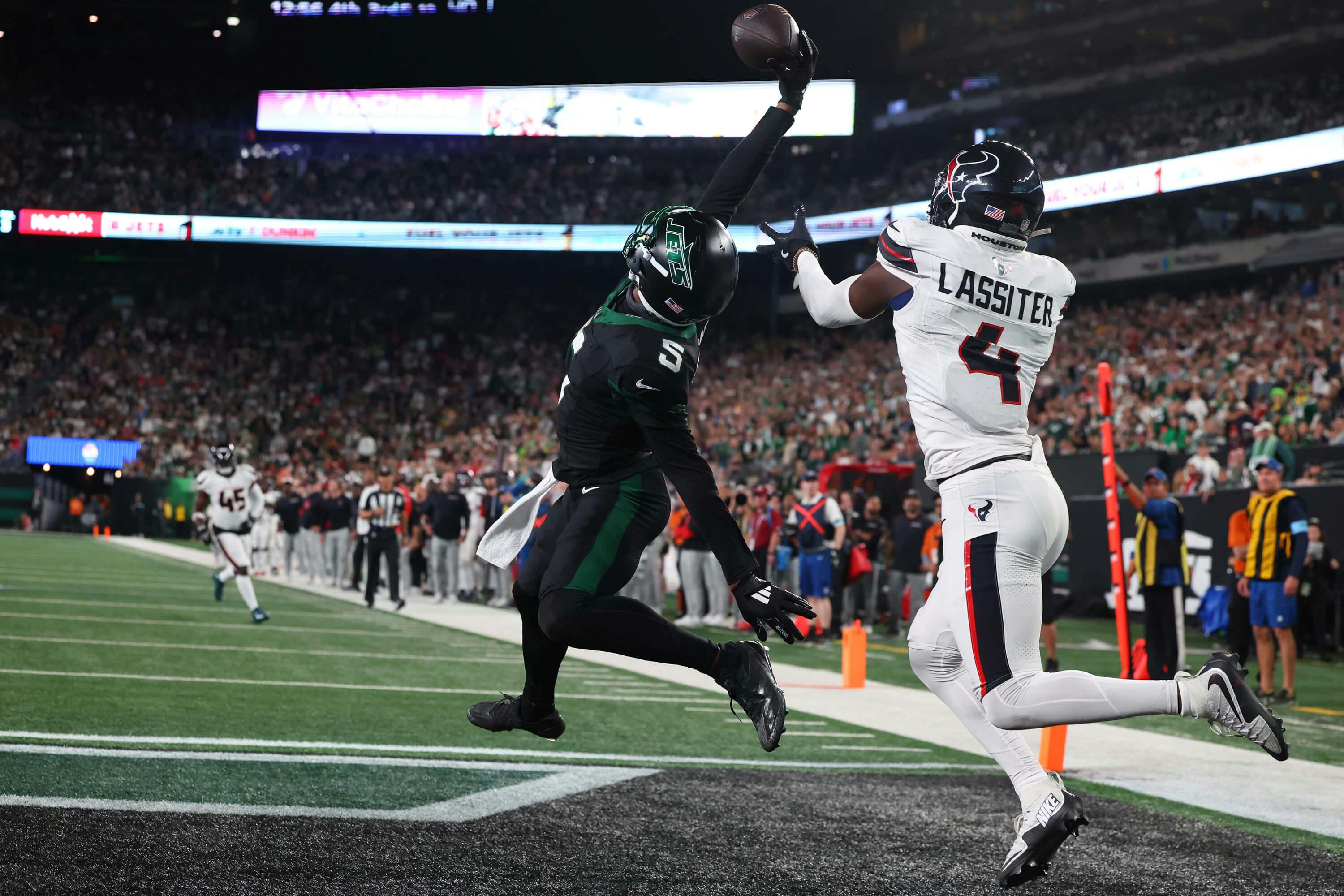 New York Jets wide receiver Garrett Wilson (5) catches a touchdown pass while being defended by Houston Texans cornerback Kamari Lassiter (4) during the second half at MetLife Stadium. Mandatory Credit: Ed Mulholland-Imagn Images