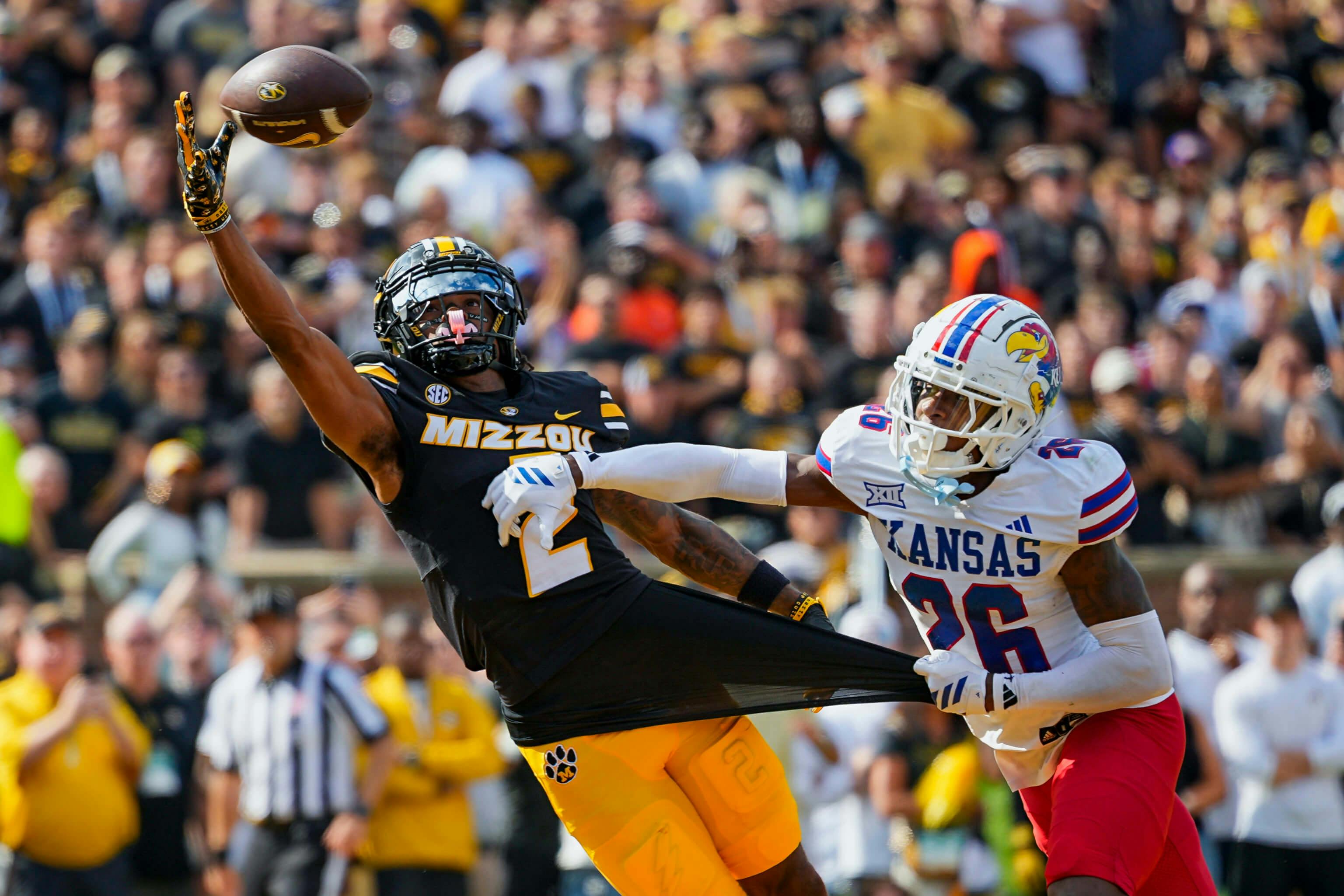 Missouri Tigers wide receiver Marquis Johnson (2) is unable to make a catch against Kansas Jayhawks defensive back Jalen Todd (26) during the first half at Faurot Field at Memorial Stadium. Jay Biggerstaff-Imagn Images