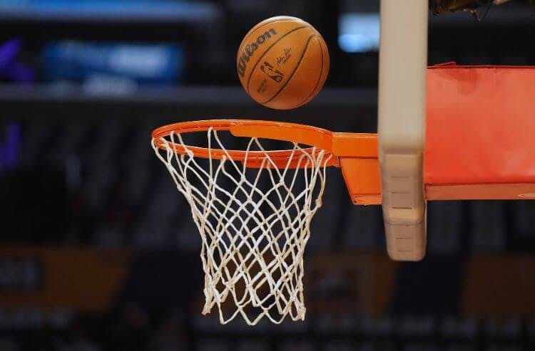 An NBA basketball bounces on the rim and into the hoop.