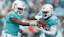 Miami Dolphins quarterback Tua Tagovailoa (1) hands off the ball to Miami Dolphins running back De'Von Achane (28) during the first quarter against the Carolina Panthers at Bank of America Stadium.