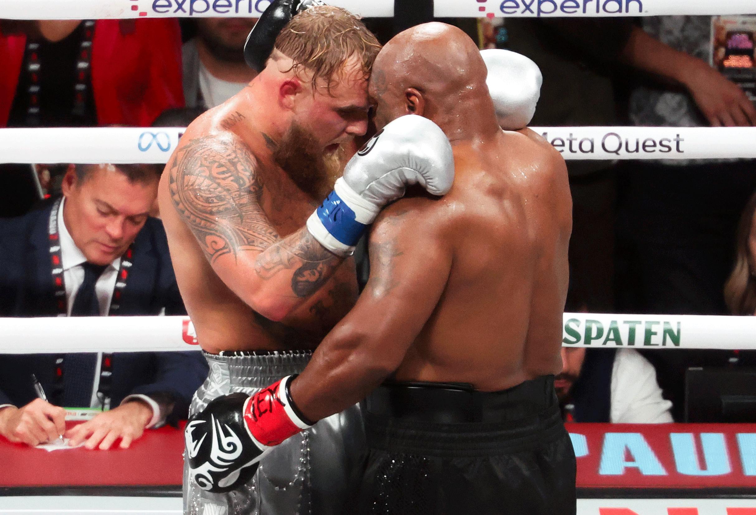 Mike Tyson (black gloves) hugs Jake Paul (silver gloves) after their fight at AT&T Stadium. Mandatory Credit: Kevin Jairaj-Imagn Images