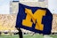 Michigan flag being carried at college game