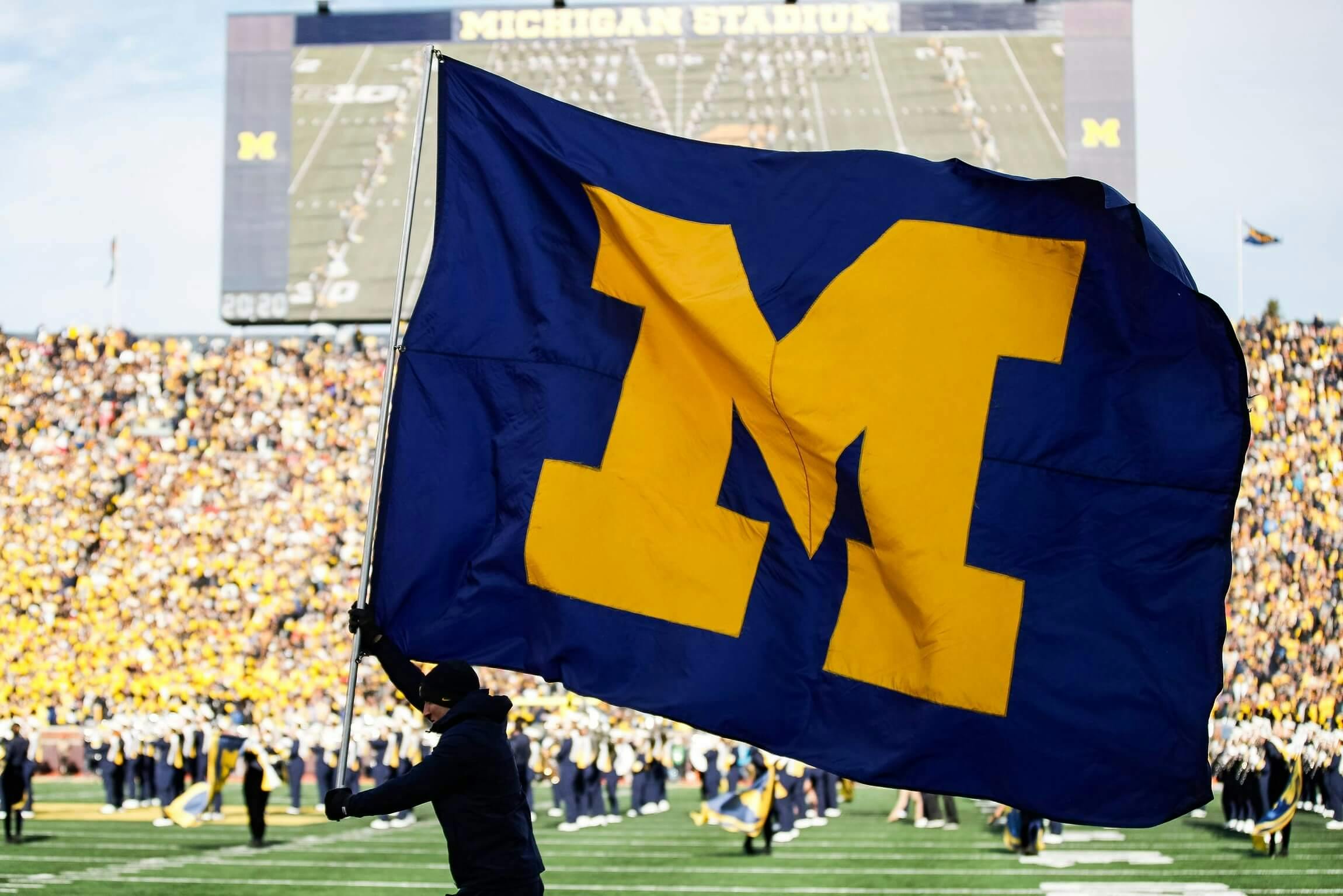 Michigan flag being carried at college game