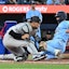 Toronto Blue Jays left fielder Davis Schneider (36) scores as New York Yankees catcher J.C. Escarra (25) misses the throw from pitcher Max Fried (not shown) in the fifth inning at Rogers Centre. Dan Hamilton-Imagn Images