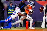 Denver Broncos wide receiver Marvin Mims Jr. (19) catches a touchdown against Buffalo Bills cornerback Dane Jackson (23) during the fourth quarter of an AFC Divisional Round playoff game at Empower Field at Mile High. Ron Chenoy-Imagn Images