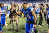 Detroit Lions wide receiver Amon-Ra St. Brown (14) tosses a turkey leg to a fan after the annual Thanksgiving Day game defeating the Chicago Bears at Ford Field. David Reginek-Imagn Images