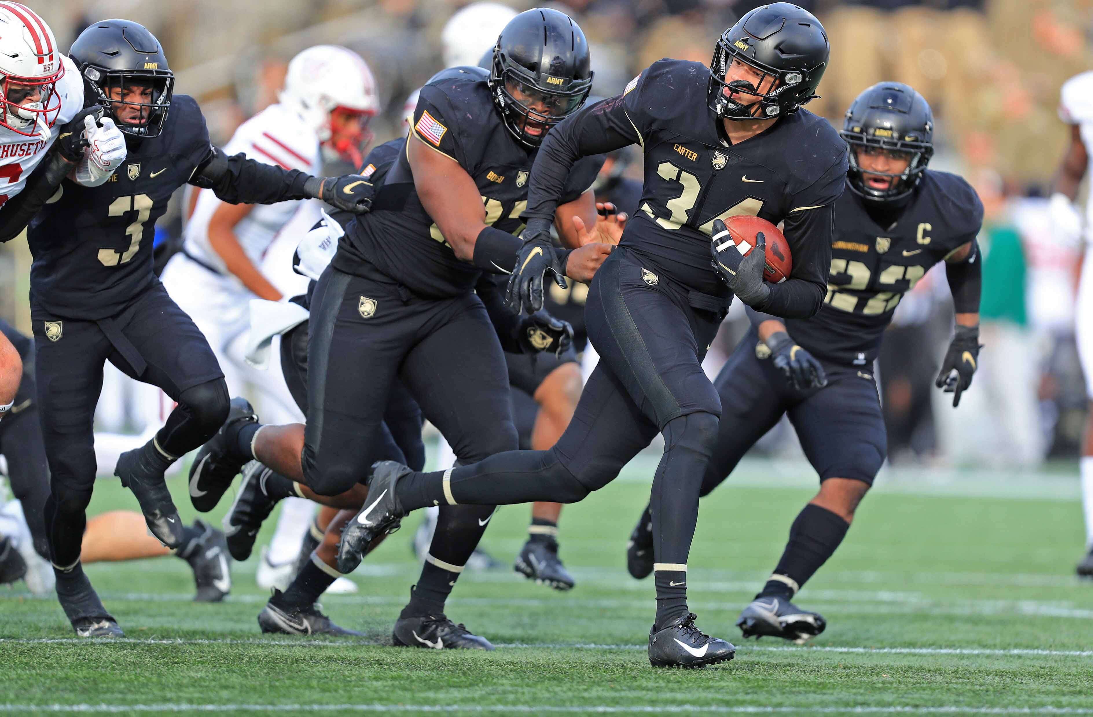 Army Black Knights outside linebacker Andre Carter (34) picks up a ball after a fumble that was later called back for a penalty against the Massachusetts Minutemen during the second half at Michie Stadium.