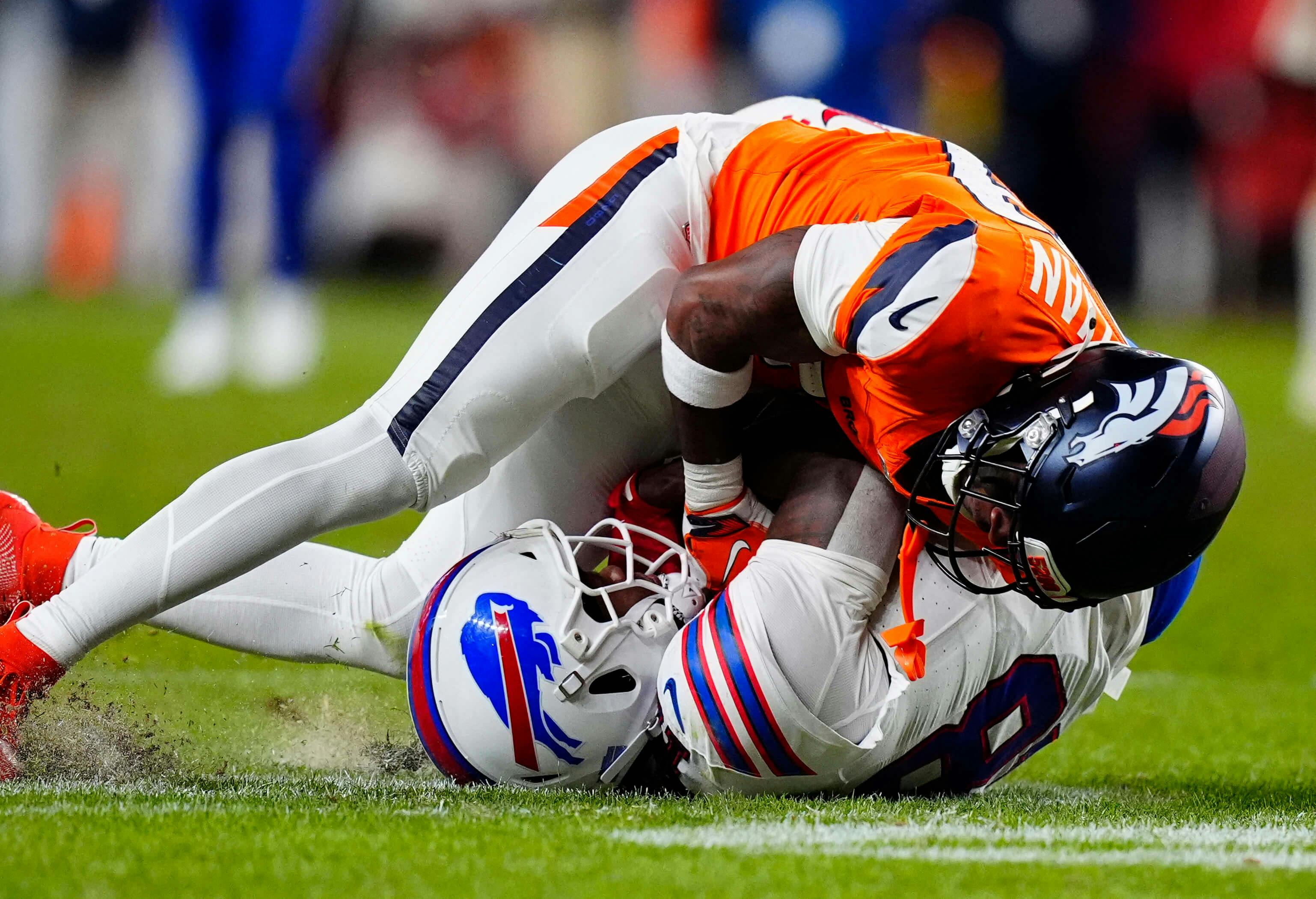 Denver Broncos cornerback Ja'quan McMillian (29) intercepts a pass intended for Buffalo Bills wide receiver Brandin Cooks (18) during overtime of an AFC Divisional Round playoff game at Empower Field at Mile High. Ron Chenoy-Imagn Images