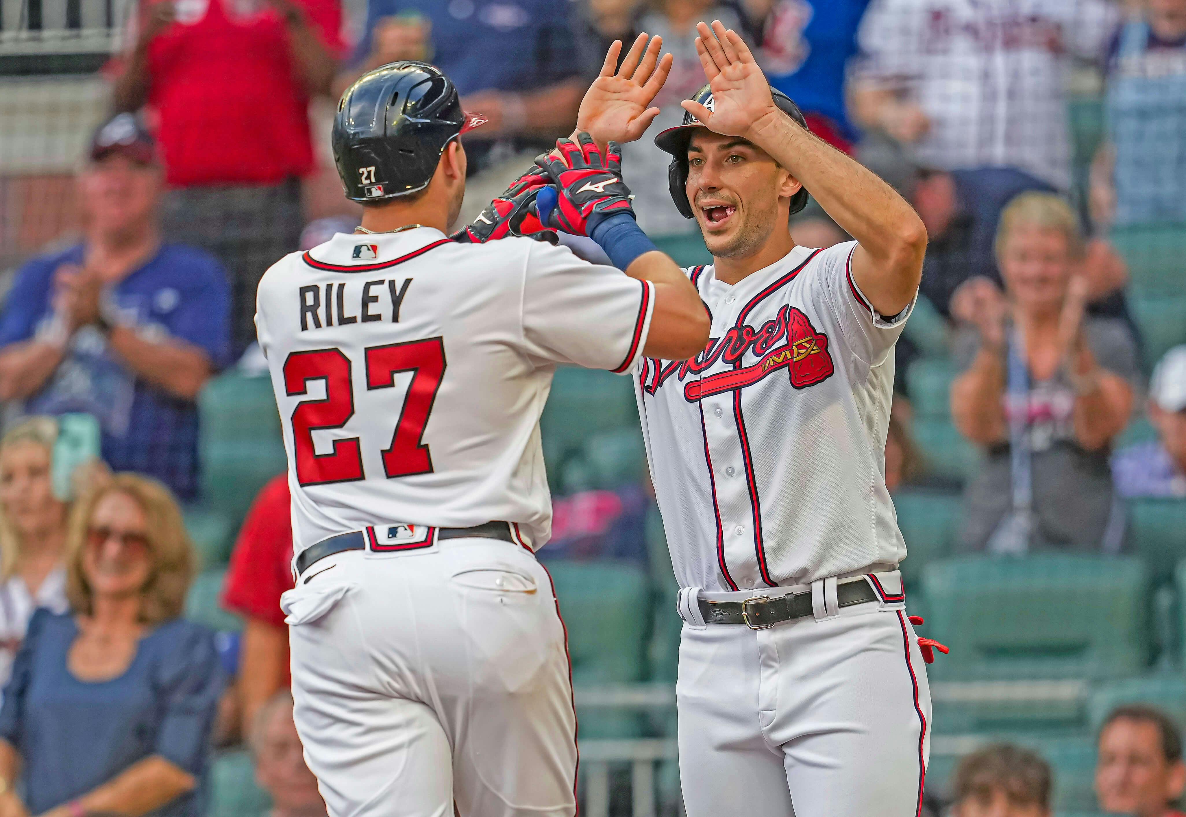 Atlanta Braves teammates Austin Riley and Matt Olson celebrate at home plate in MLB action.