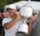 Brooks Koepka is handed the Wanamaker Trophy on the 18th green following his victory at the PGA Championship at Oak Hill Country Club Sunday, May 21, 2023.