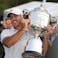 Brooks Koepka is handed the Wanamaker Trophy on the 18th green following his victory at the PGA Championship at Oak Hill Country Club Sunday, May 21, 2023.
