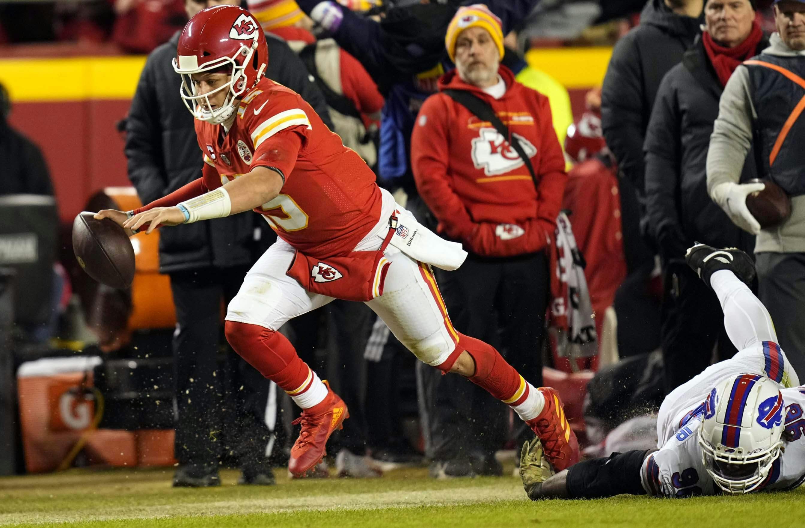 Kansas City Chiefs quarterback Patrick Mahomes (15) scrambles up the field against Buffalo Bills defensive end Boogie Basham (96) during the third quarter of the AFC Divisional playoff football game at GEHA Field at Arrowhead Stadium.