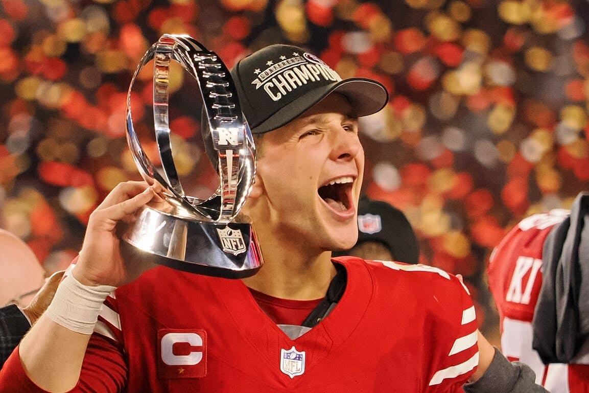 San Francisco 49ers quarterback Brock Purdy (13) holds the George Halas Trophy while after winning the NFC Championship football game against the Detroit Lions at Levi's Stadium.