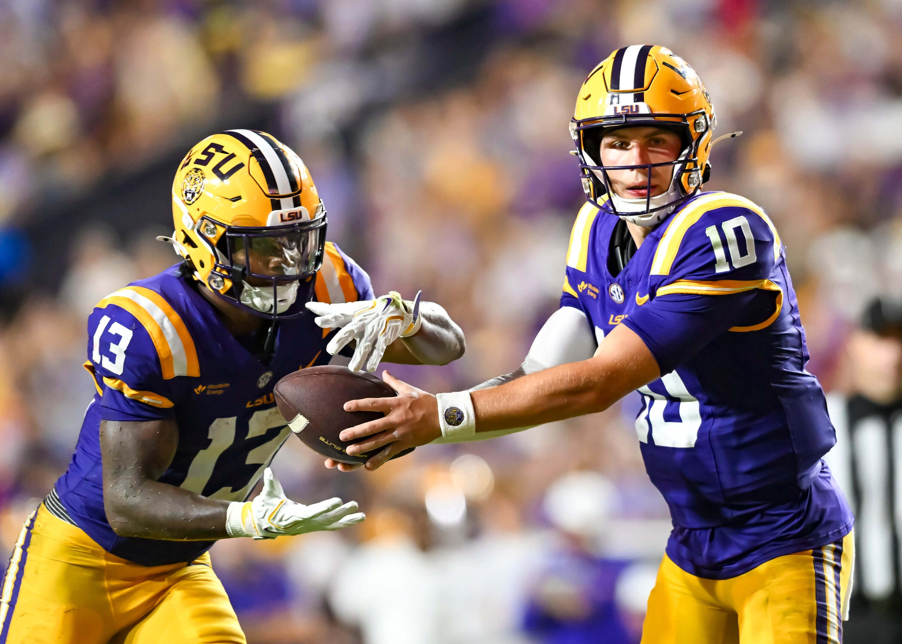 LSU vs Ole Miss betting guide, LSU quarterback Sam Leavitt hands off to running back Dilin Jones.