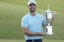 Wyndham Clark poses with the championship trophy after winning the U.S. Open golf tournament at Los Angeles Country Club. 