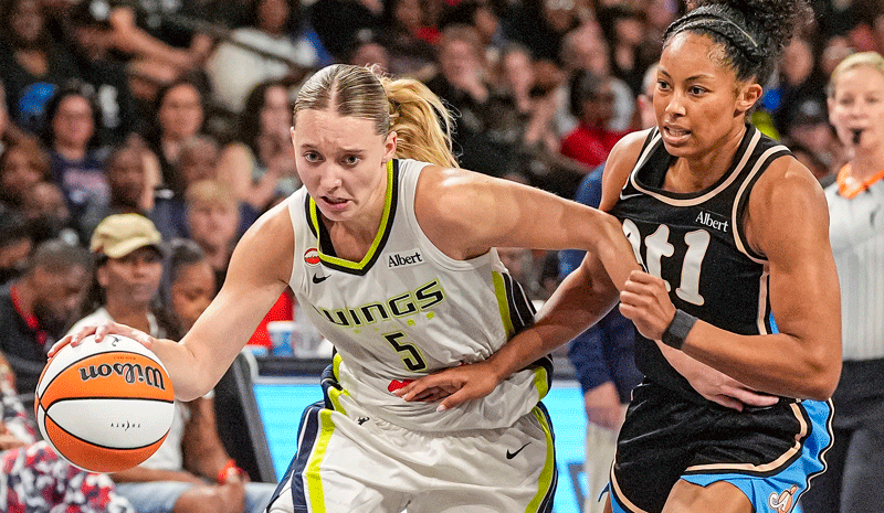 Paige Bueckers (5) drives with the ball against Atlanta Dream guard Indya Nivar.