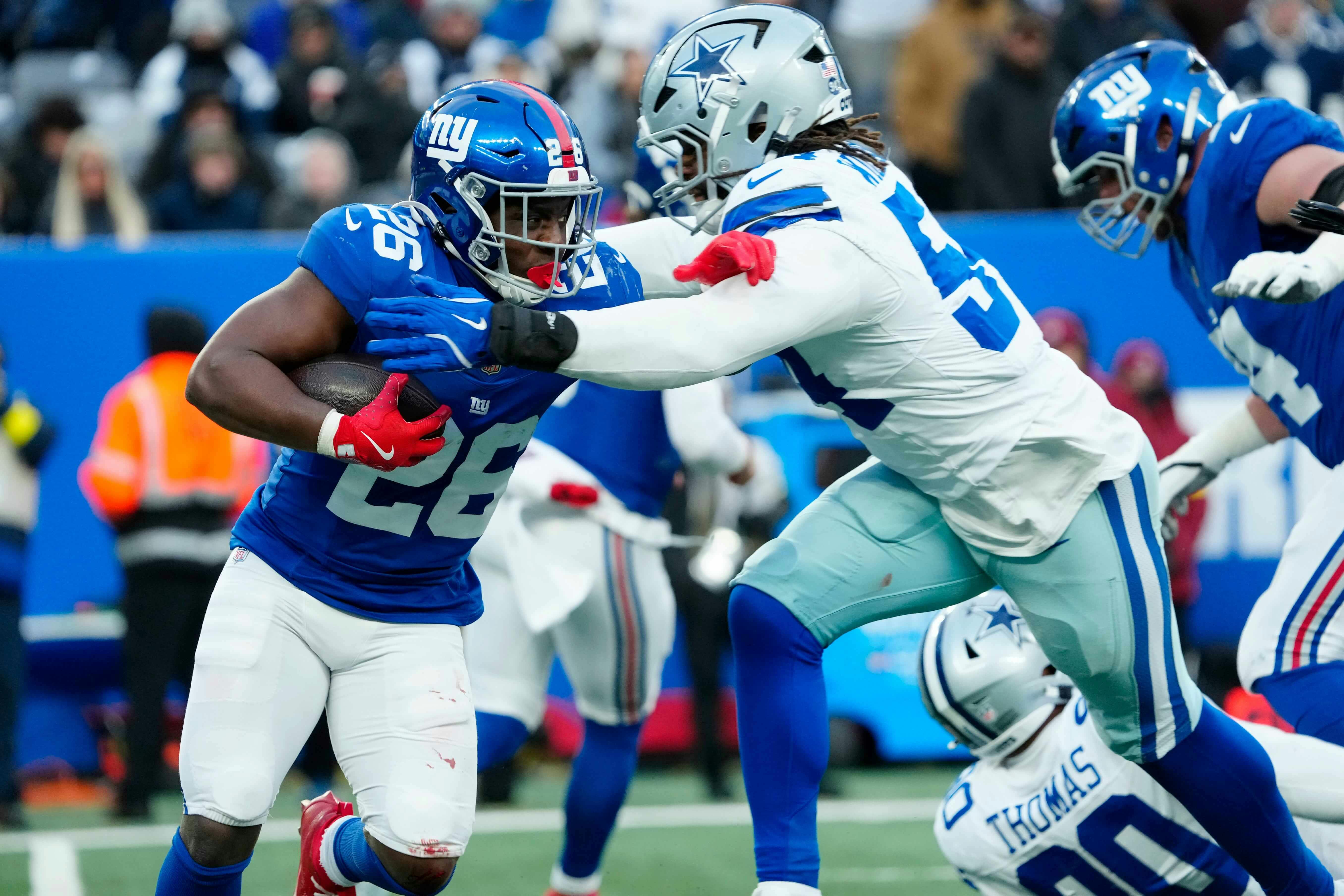 New York Giants running back Devin Singletary (26) tries to run past Dallas Cowboys defensive end Sam Williams (54), Sunday, January 4, 2026, in East Rutherford. Kevin R. Wexler-NorthJersey.com / USA TODAY NETWORK via Imagn Images