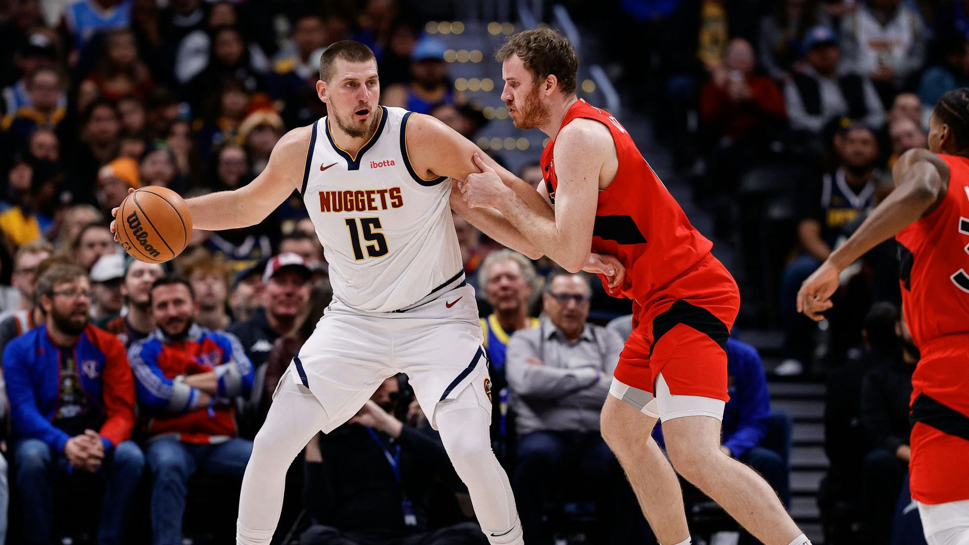 Denver Nuggets center Nikola Jokic (15) controls the ball as Toronto Raptors center Jakob Poeltl (19) guards.