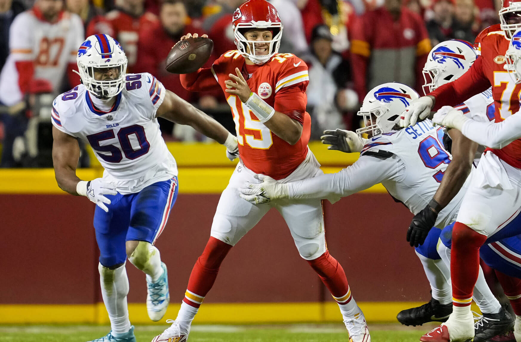 Kansas City Chiefs quarterback Patrick Mahomes (15) throws a pass against Buffalo Bills defensive end Greg Rousseau (50) and defensive tackle Tim Settle (99) during the second half at GEHA Field at Arrowhead Stadium.