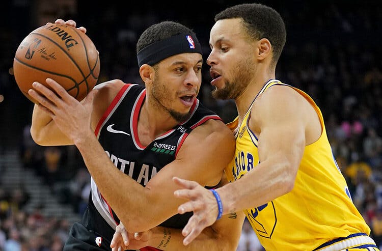 Seth Curry is guarded by his brother Steph in NBA action.
