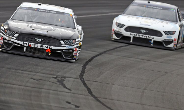 Aric Almirola races Kevin Harvick in NASCAR action.