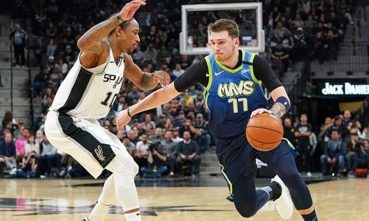 Luka Doncic of the Dallas Mavericks against the San Antonio Spurs' Demar DeRozan