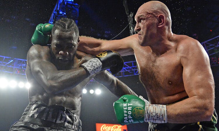 Tyson Fury throws a punch against Deontay Wilder in boxing action.