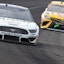 Kevin Harvick drives ahead of Kyle Busch in NASCAR action.